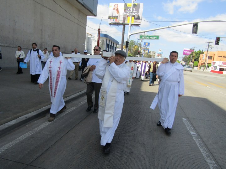 El Arzobispo es ayudado por sacerdote a cargar la cruz