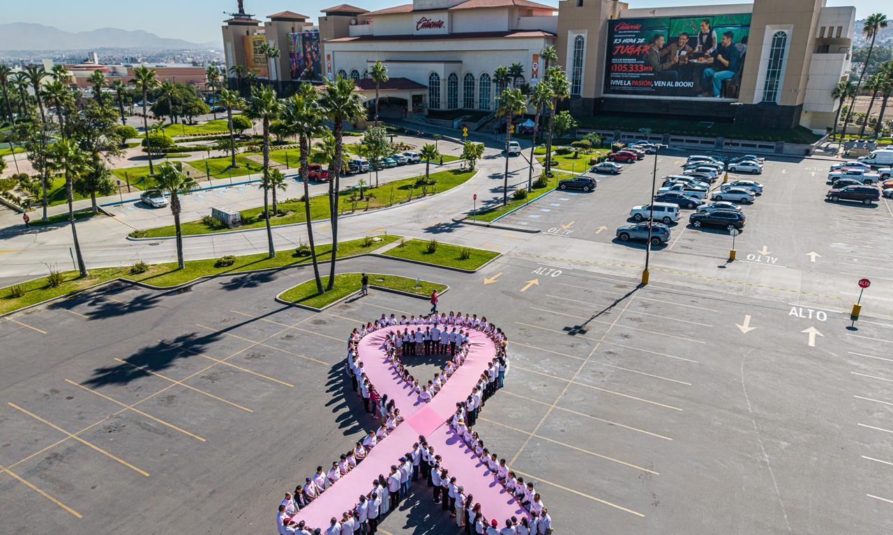 Colaboradores de Corporación Caliente forman lazo rosa humano por el Día Mundial contra el Cáncer de Mama
